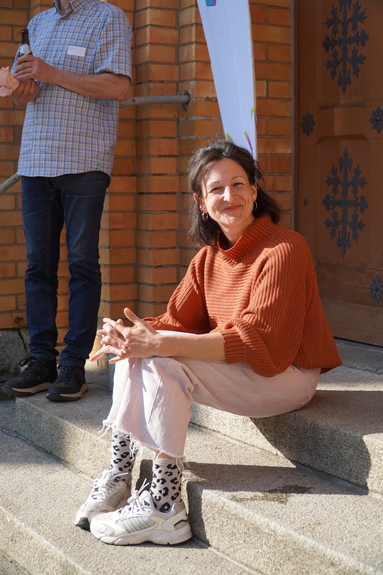 Rebekka sitzt vor der PAX Jugendkirche.