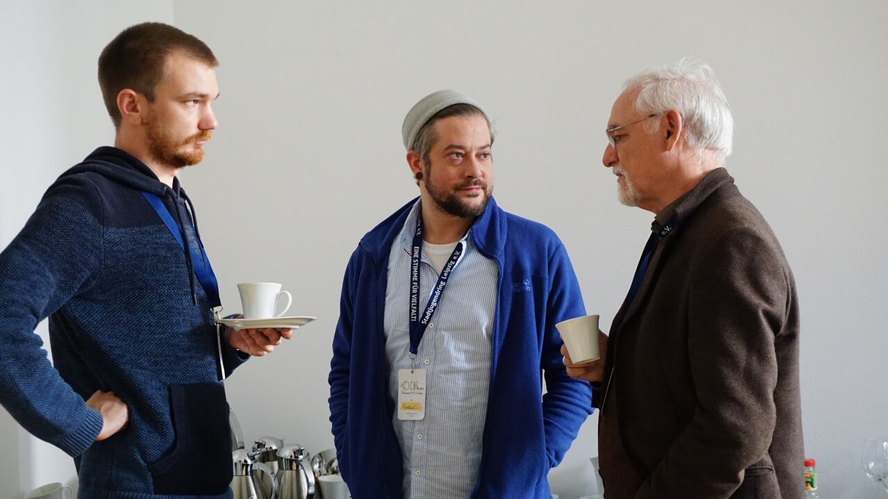 Drei Menschen unterhalten sich während einer Pause.