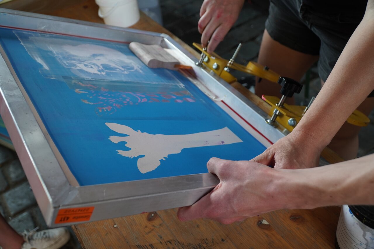 Menschen machen Siebdruck.